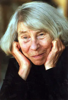 An older lady with a grey bob smiling gently.