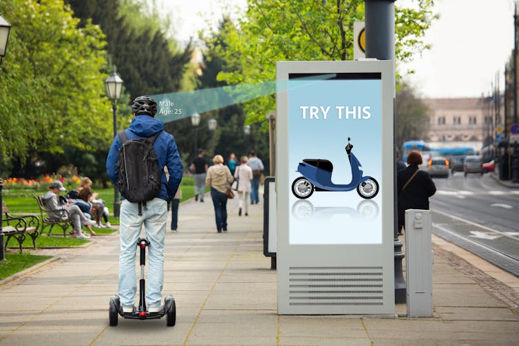 Person riding an upright vehicle being 'targeted' by an advert screen showing an alternative with the words 'try this'.
