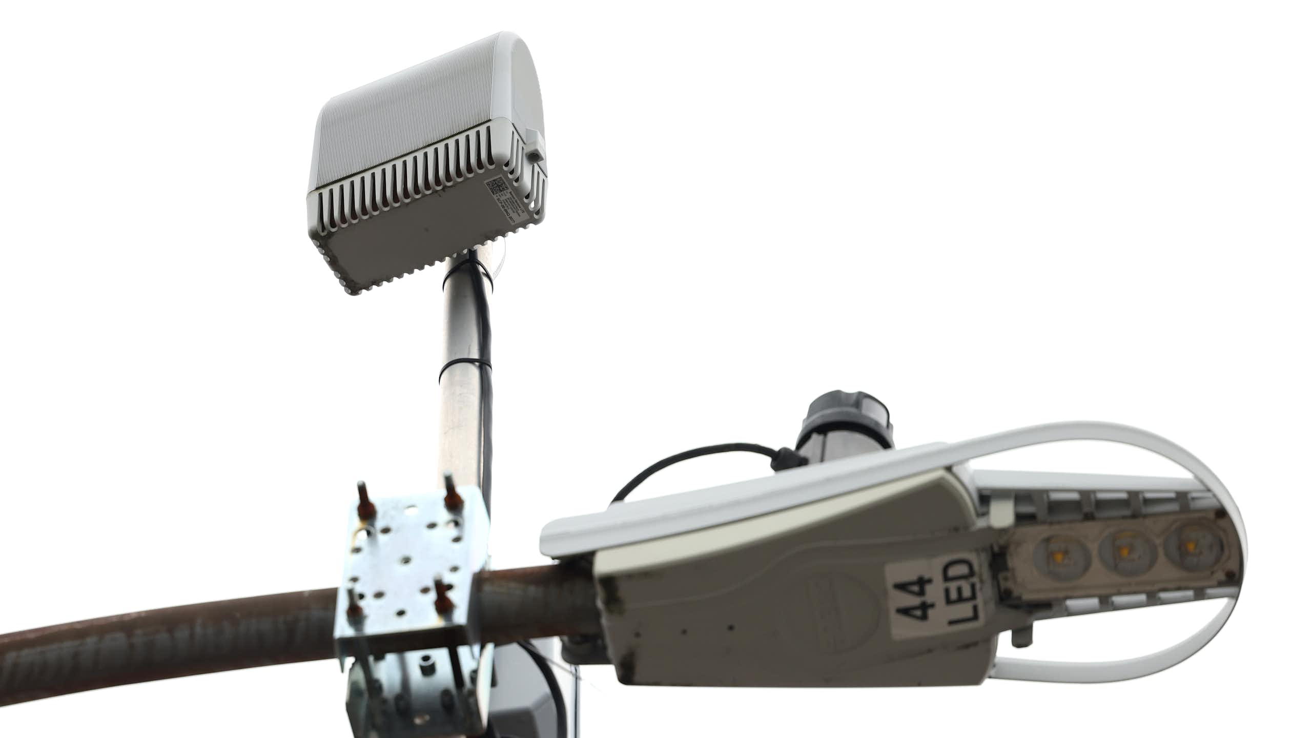 a device bolted to the top of a street lamp