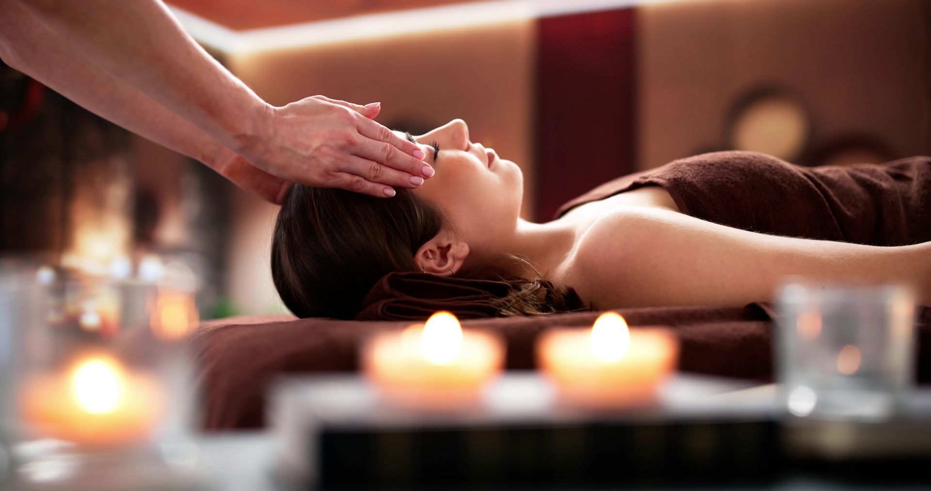 Alguien coloca las manos en las dos sienes de una mujer.