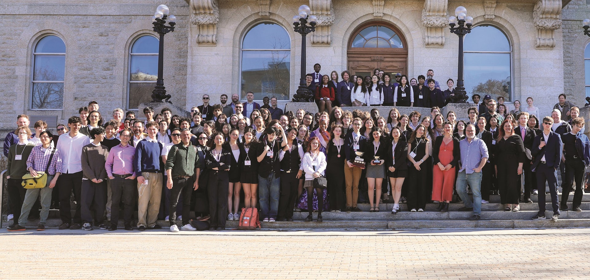 Filas de muchas personas paradas en las escaleras en filas y posando para una foto.