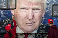 Des supporters MAGA écrivent des messages autour d’une photo de Donald Trump