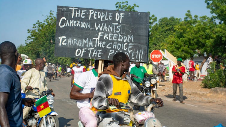 People demonstrates on the street with signs.