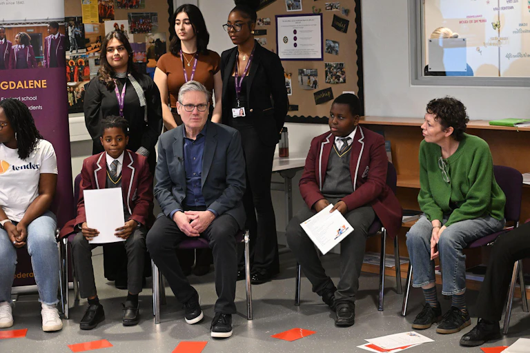 Keir Starmer and Olivia Coleman sitting with school pupils.