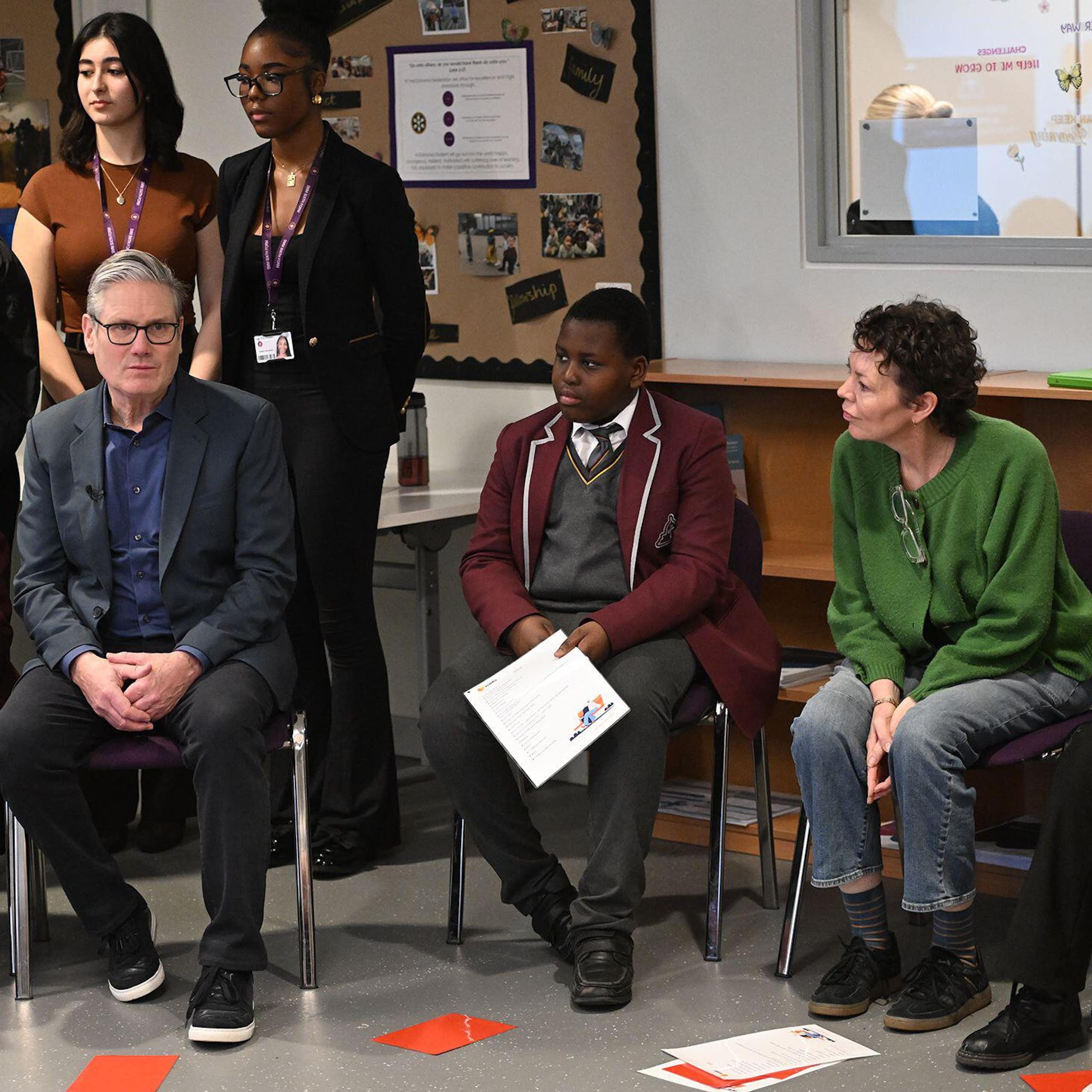 Keir Starmer and Olivia Coleman sitting with school pupils.