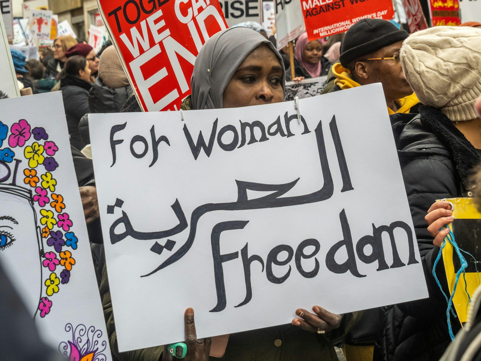 A protester holding a sign that reads 'for woman freedom'.