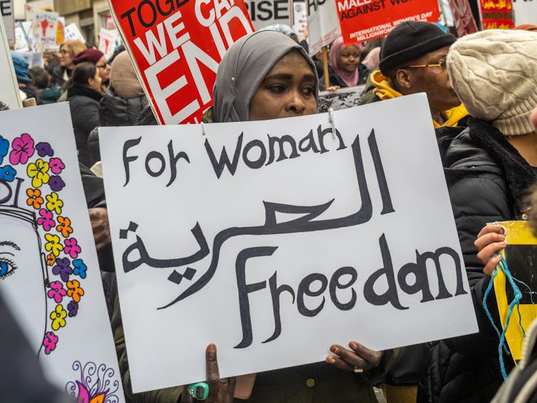 A protester holding a sign that reads 'for woman freedom'.