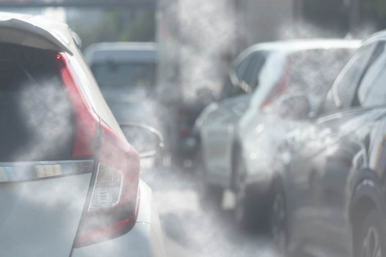exhaust fumes surrounding several cars.