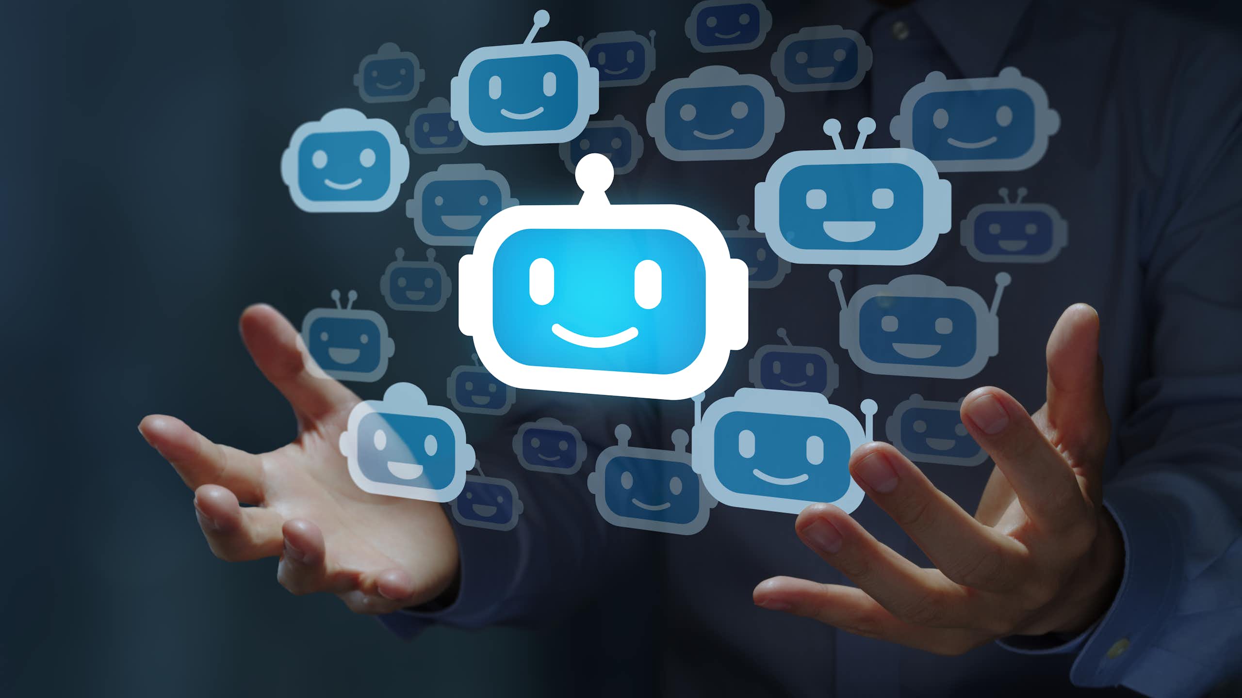 a couple dozen robot face emojis floating between two human hands