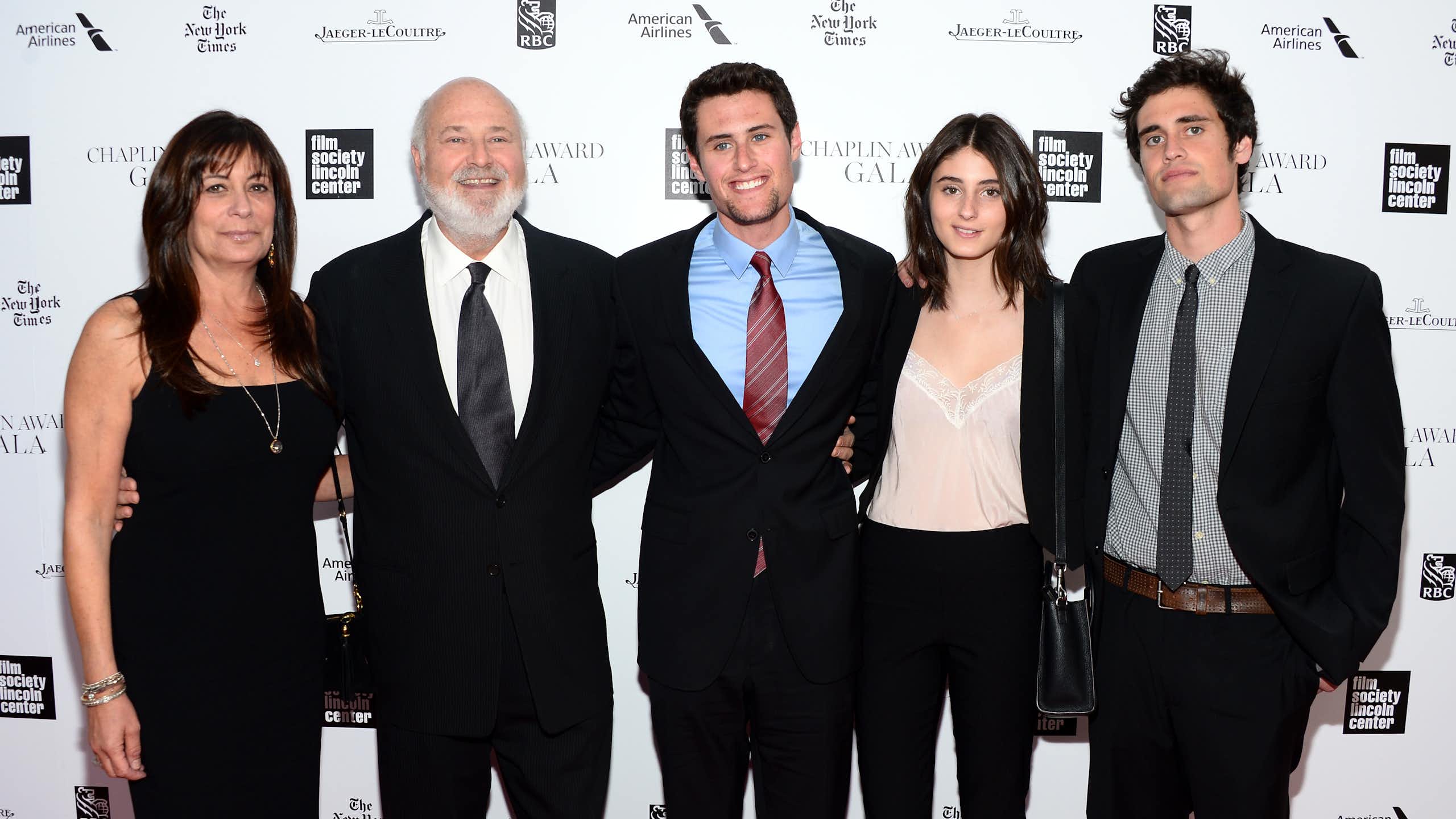 Five people in dressy attire pose for a family photo that includes Rob Reiner.