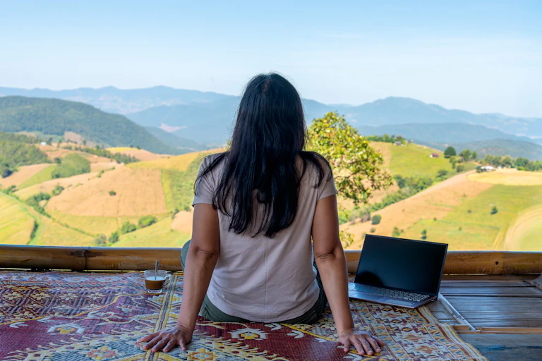 A digital nomad works on their laptop while looking out on terraced rice fields in Chiang Mai, northern Thailand.