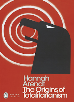 The red, white and black cover of a book by Hannah Arendt called The Origins of Totalitarianism.