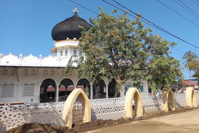 Sebuah masjid di Pidie Jaya, Aceh dengan pekarangan berlumpur setelah diterjang banjir Sumatra.