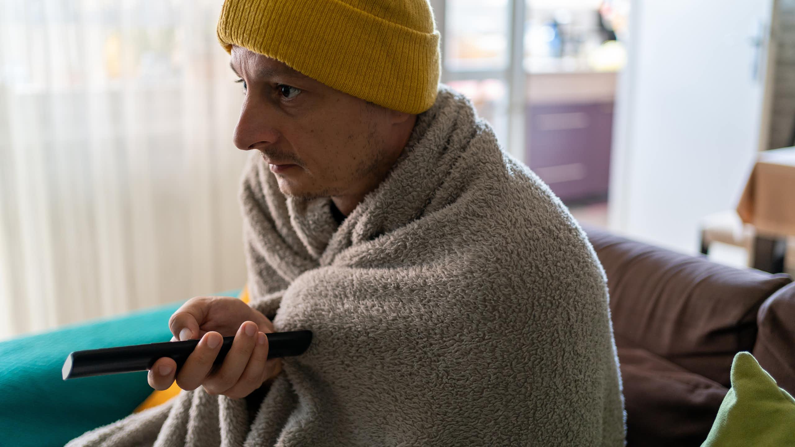 Un homme se couvre chaudement pour faire face à la précarité énergétique