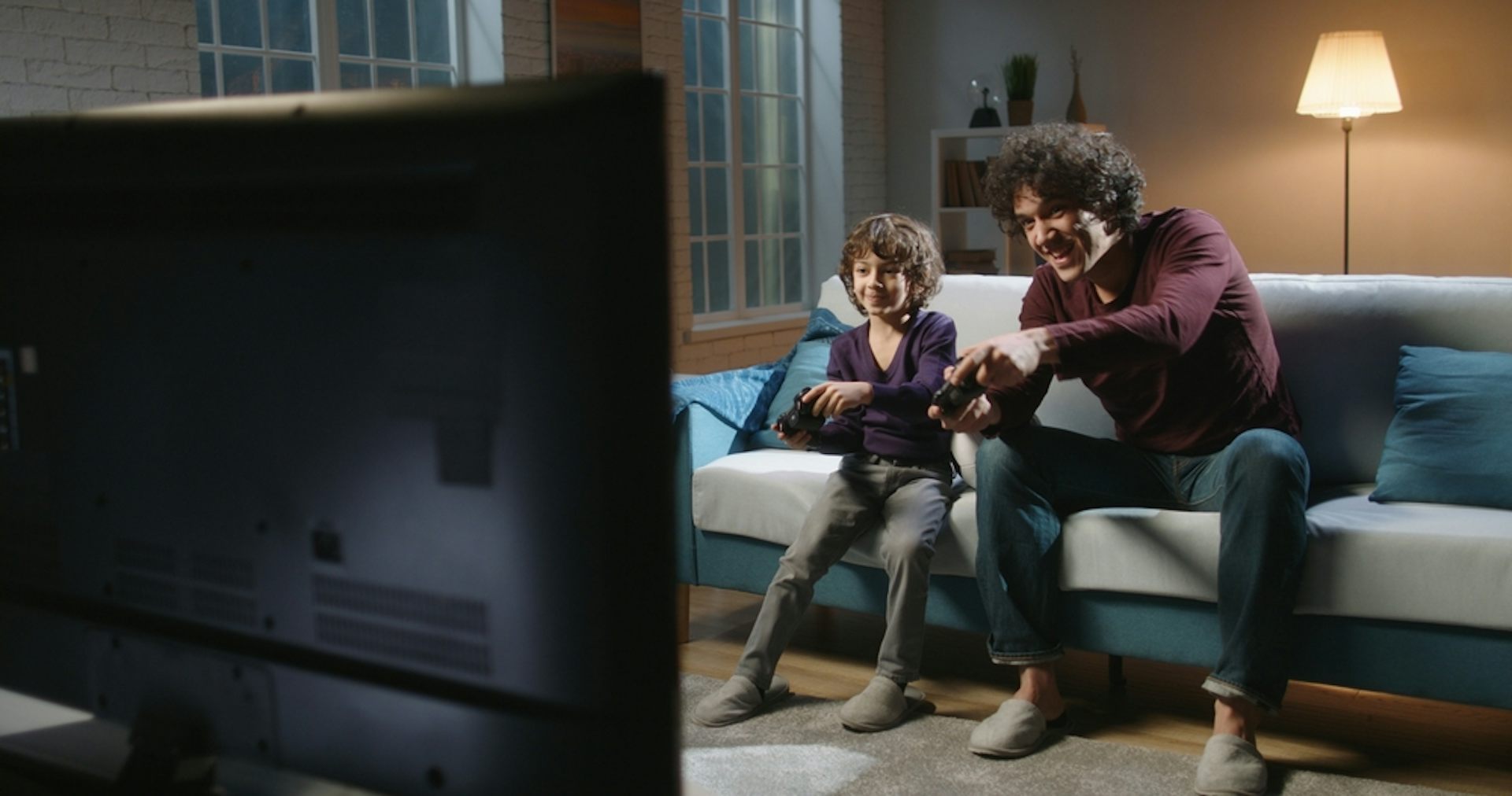 Un père et son fils jouent à un jeu vidéo.