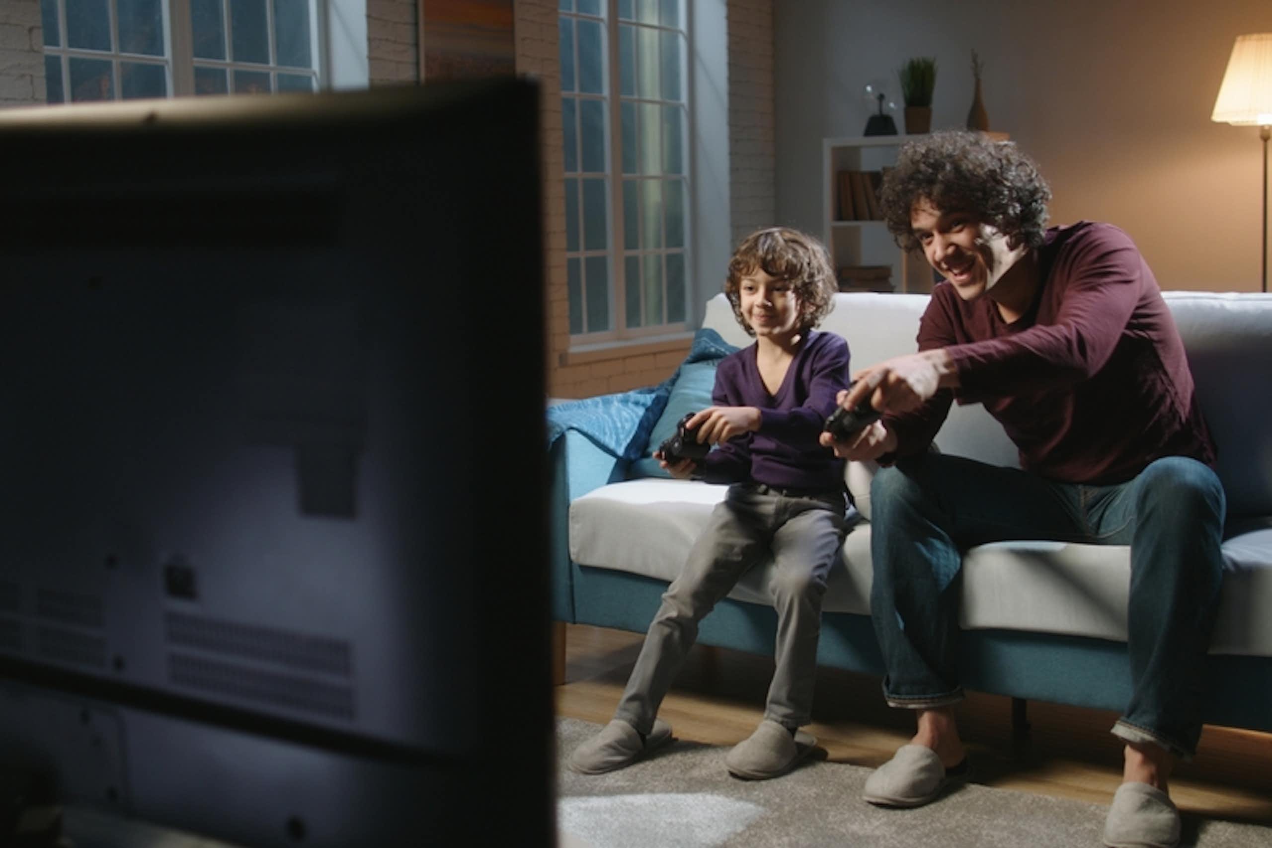 Un père et son fils jouent à un jeu vidéo.