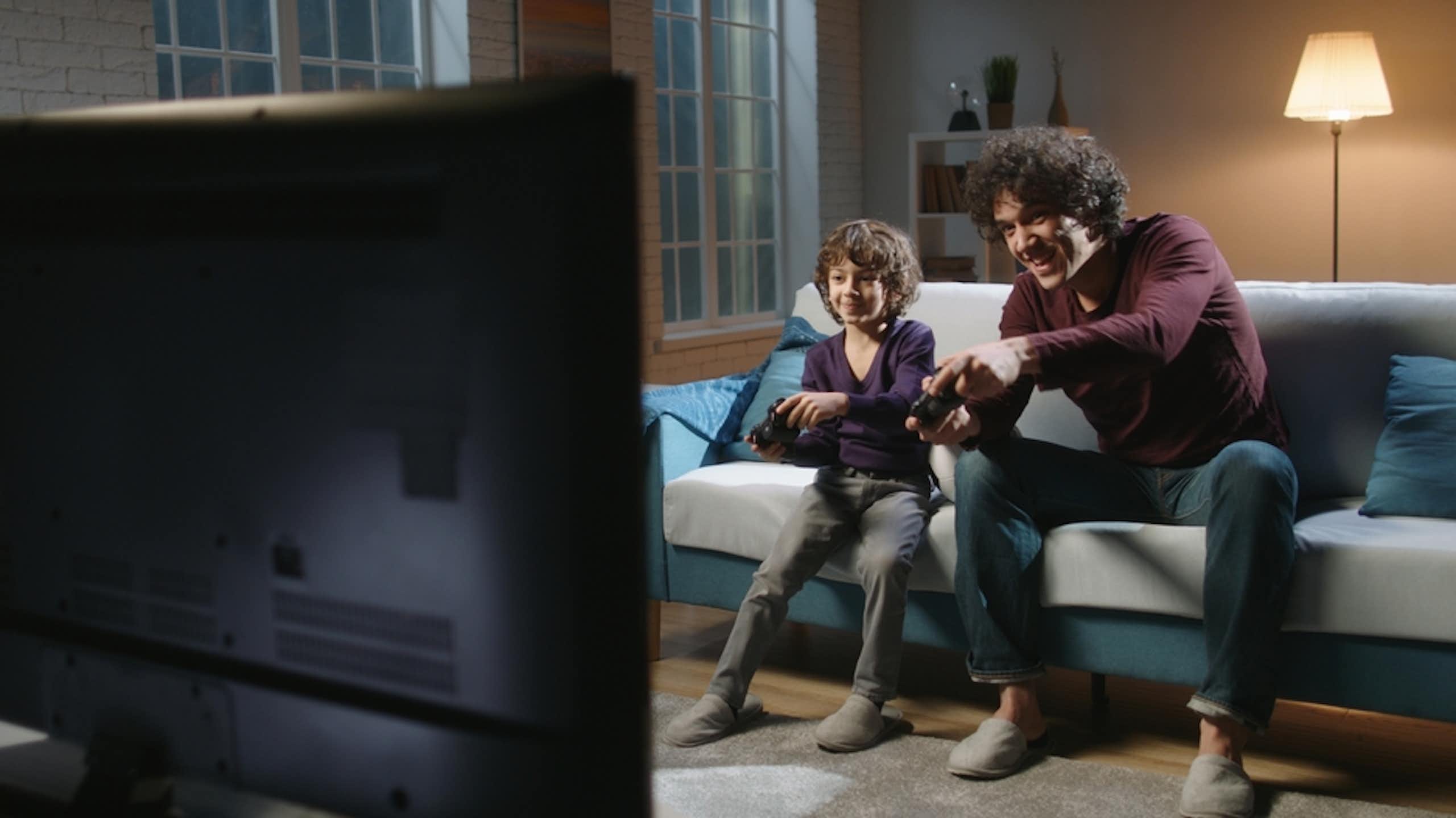 Un père et son fils jouent à un jeu vidéo.