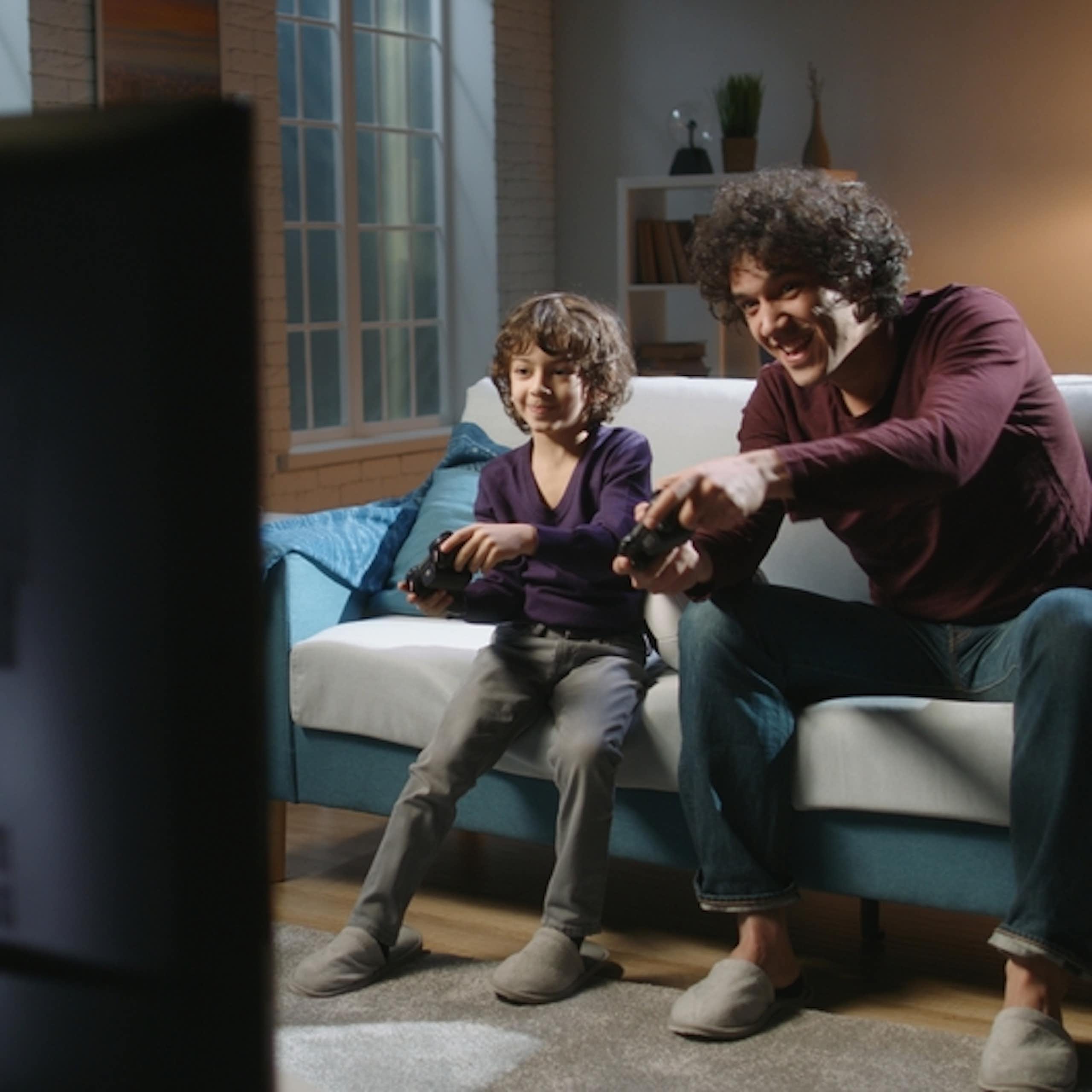 Un père et son fils jouent à un jeu vidéo.