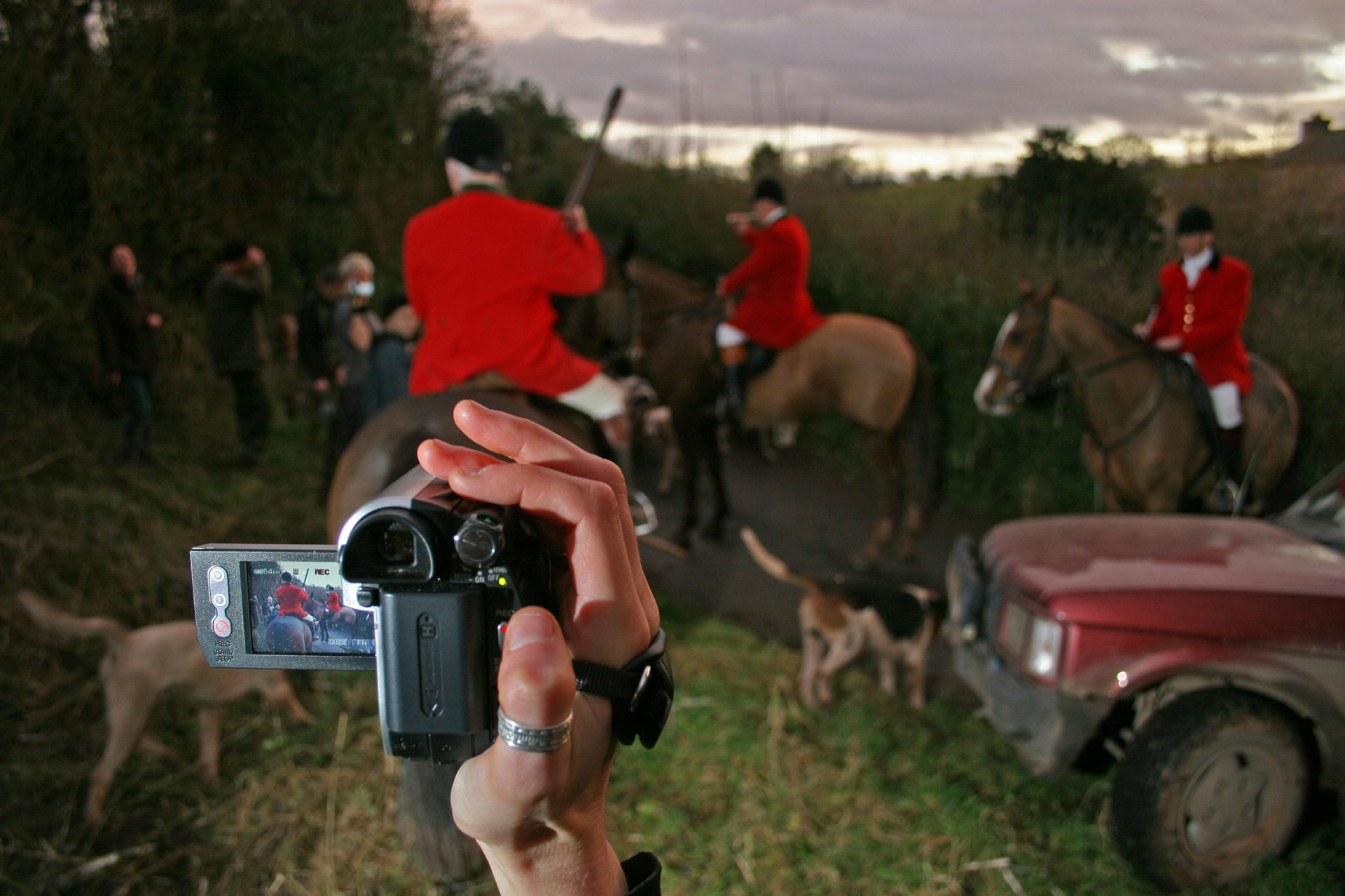 Members of the South Herefordshire Hunt on horseback are filmed by a hunt saboteur