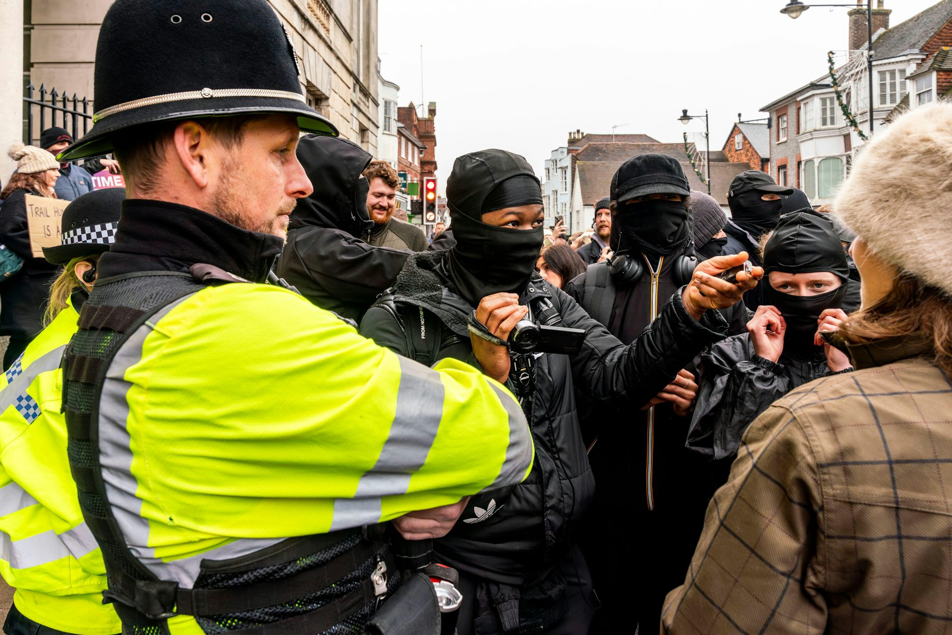 Pro- and anti-hunt groups confront each other in a street as a policeman watches on.