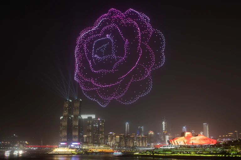 Una flor formada con luces en el cielo nocturno de una ciudad.