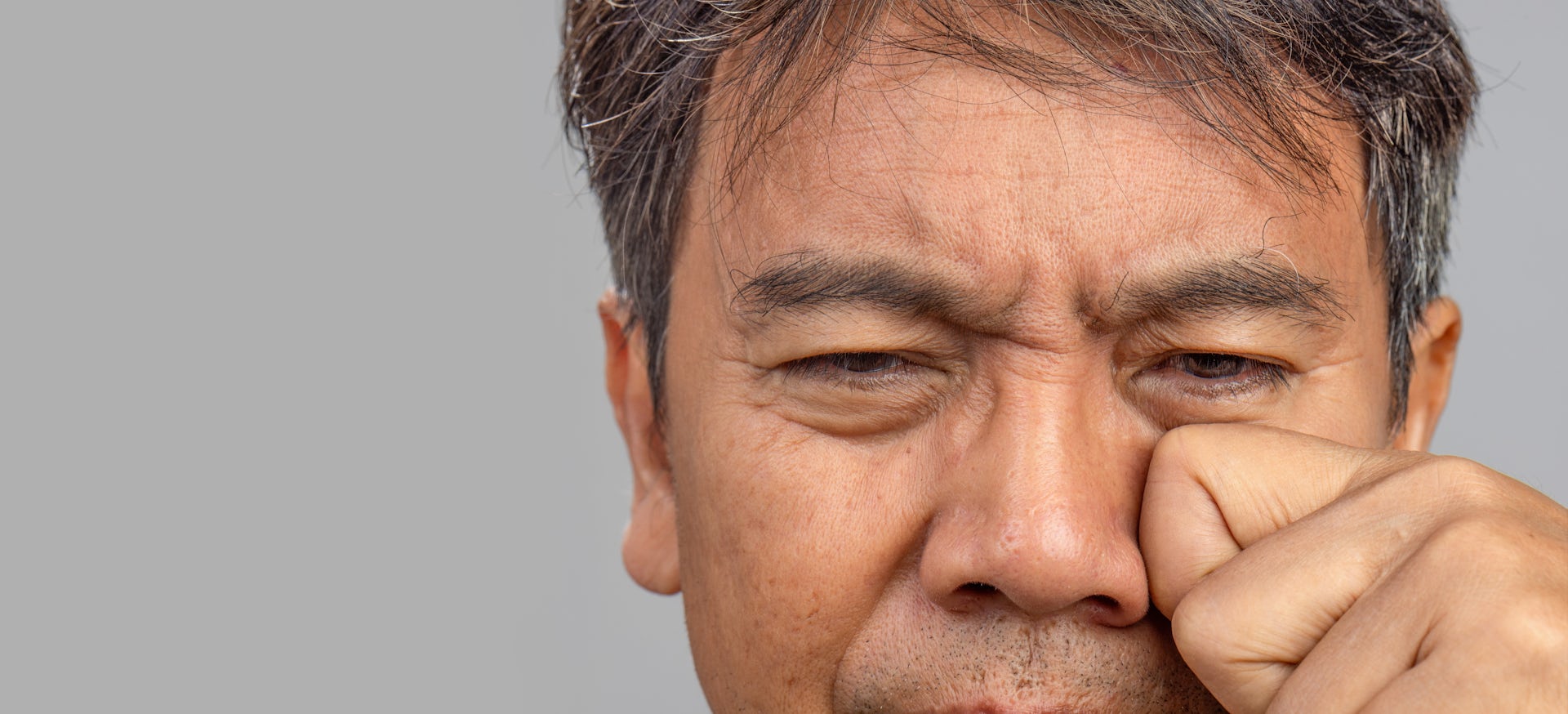 A man rubbing under his eye.