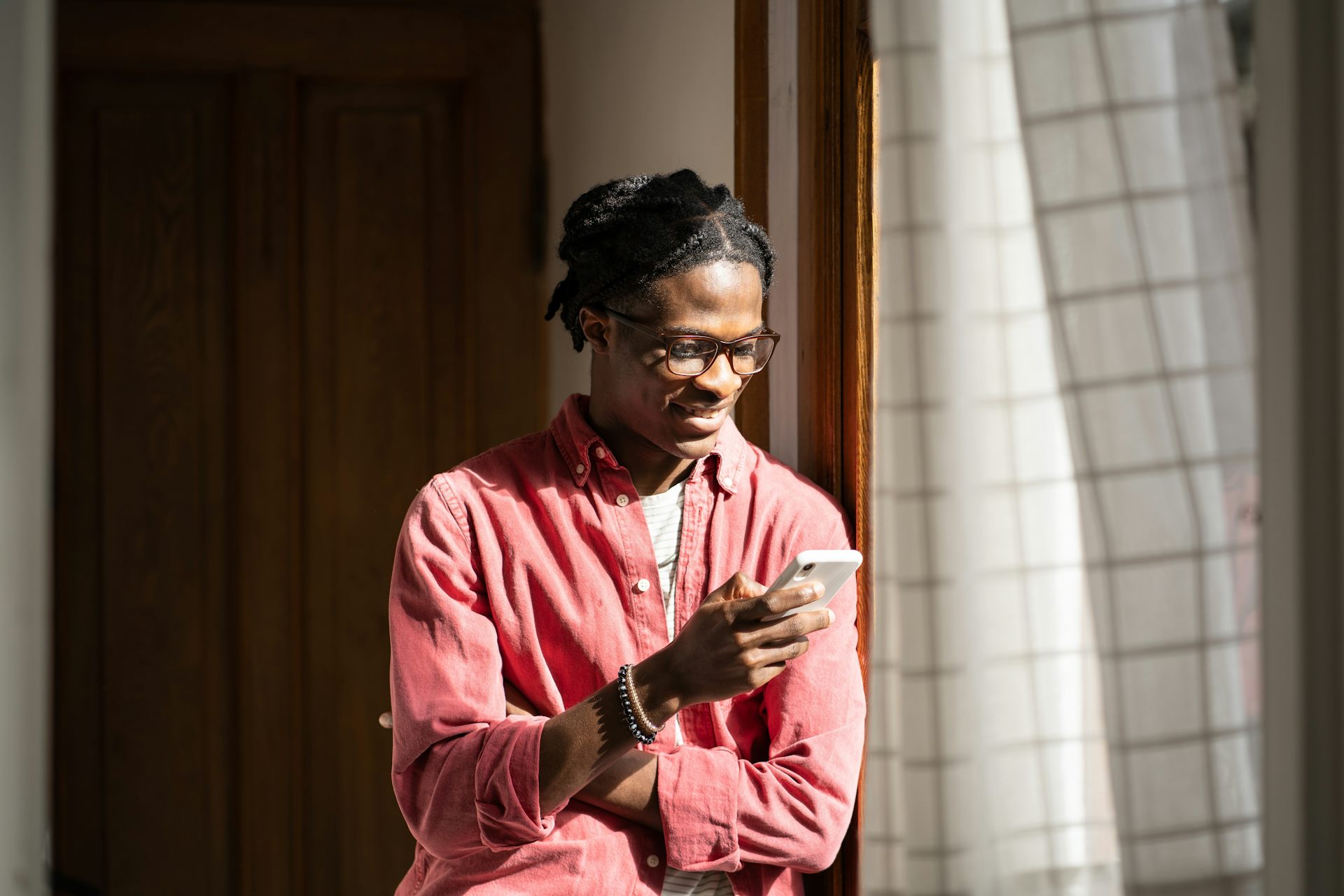 A young man scrolling on his phone indoors