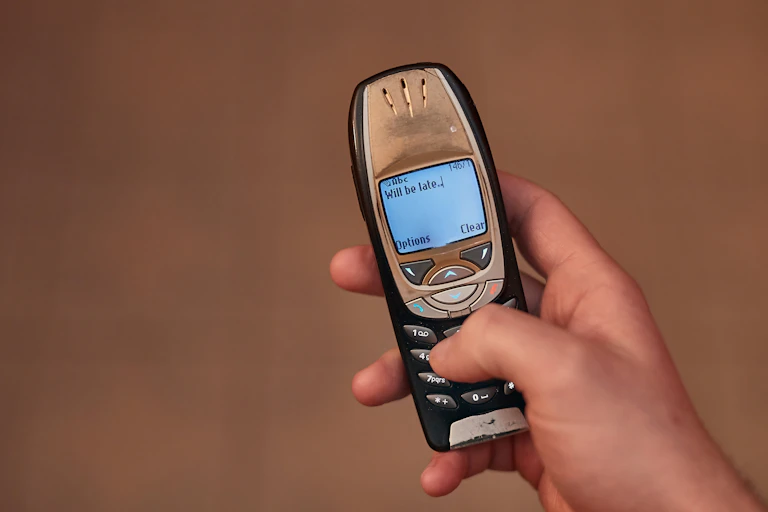 Un usuario escribe un SMS en un modelo antiguo de móvil.