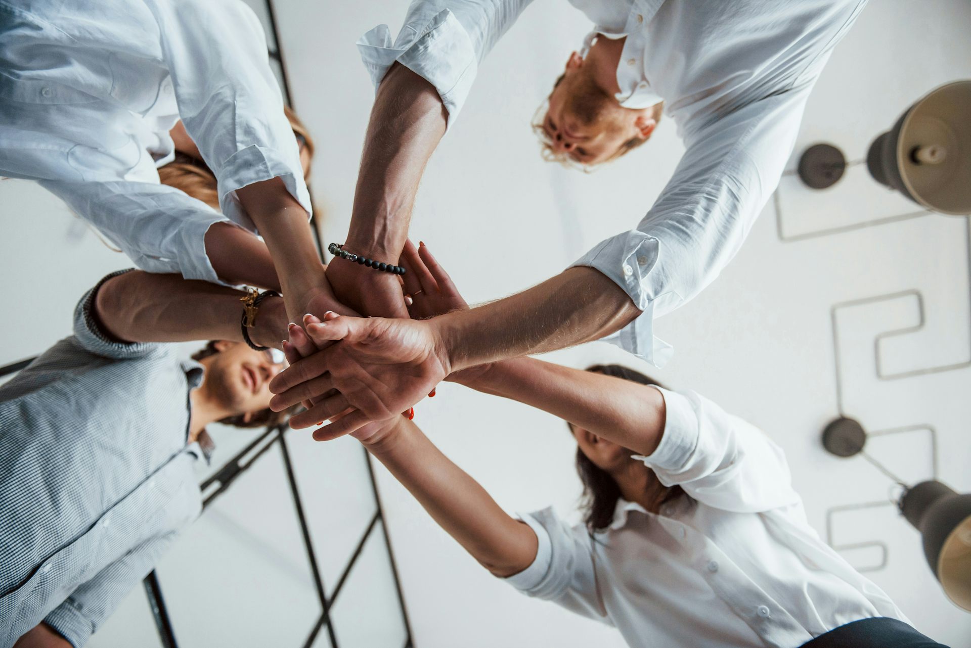 A group of people putting their hands together in a circle