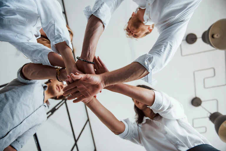 A group of people putting their hands together in a circle