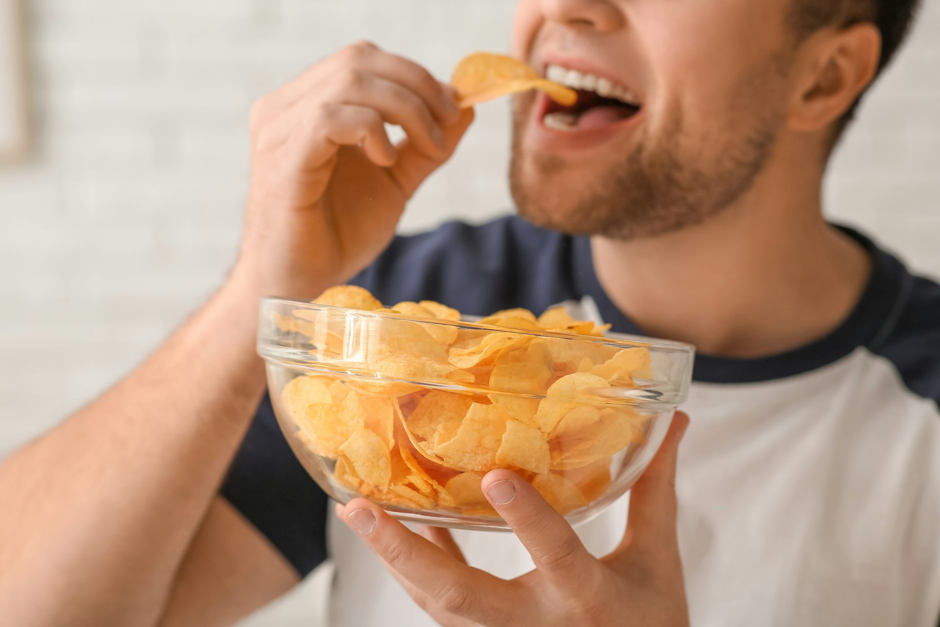 Un hombre comiendo patatas fritas.