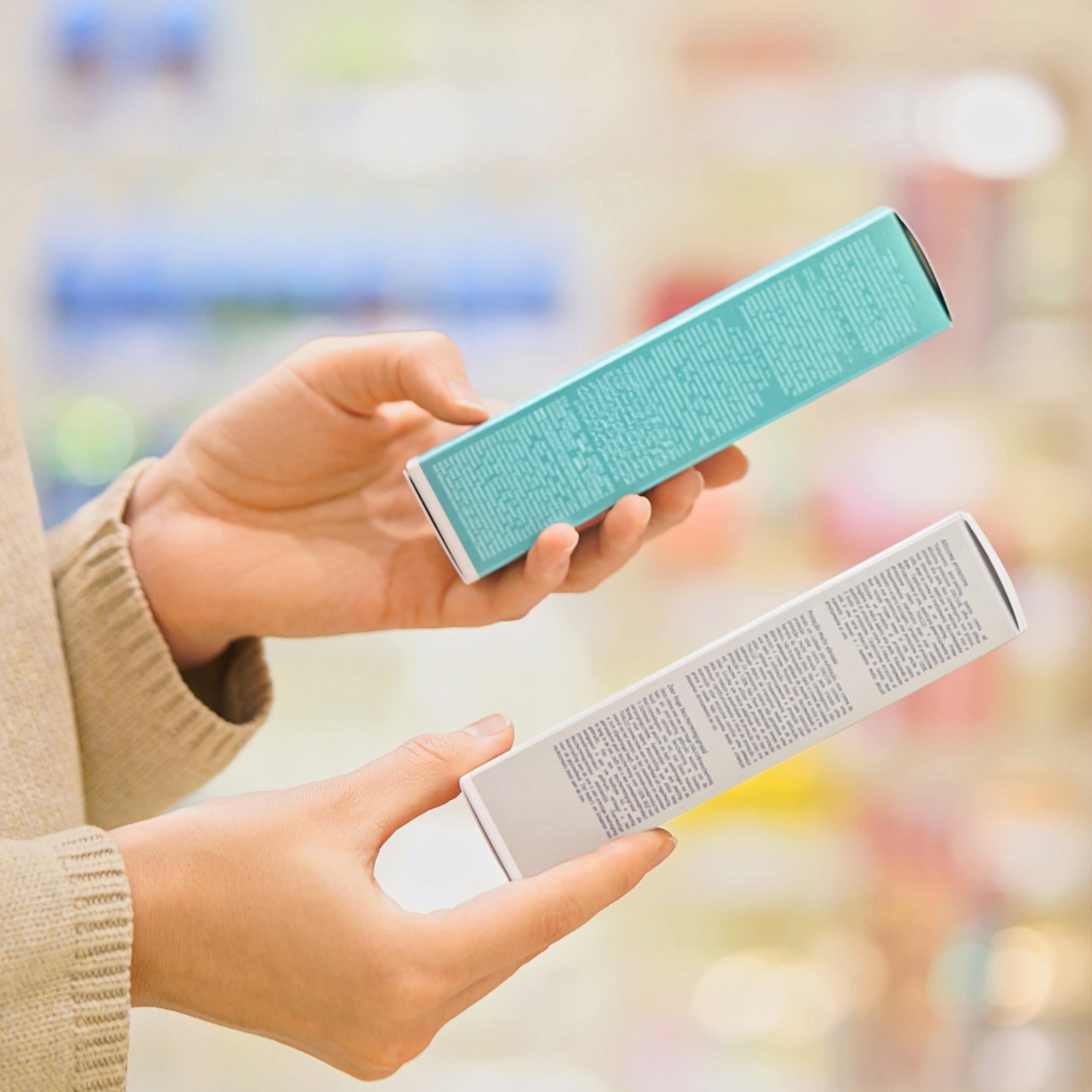 Photo d’une personne en train d’hésiter entre deux sortes de cosmétiques