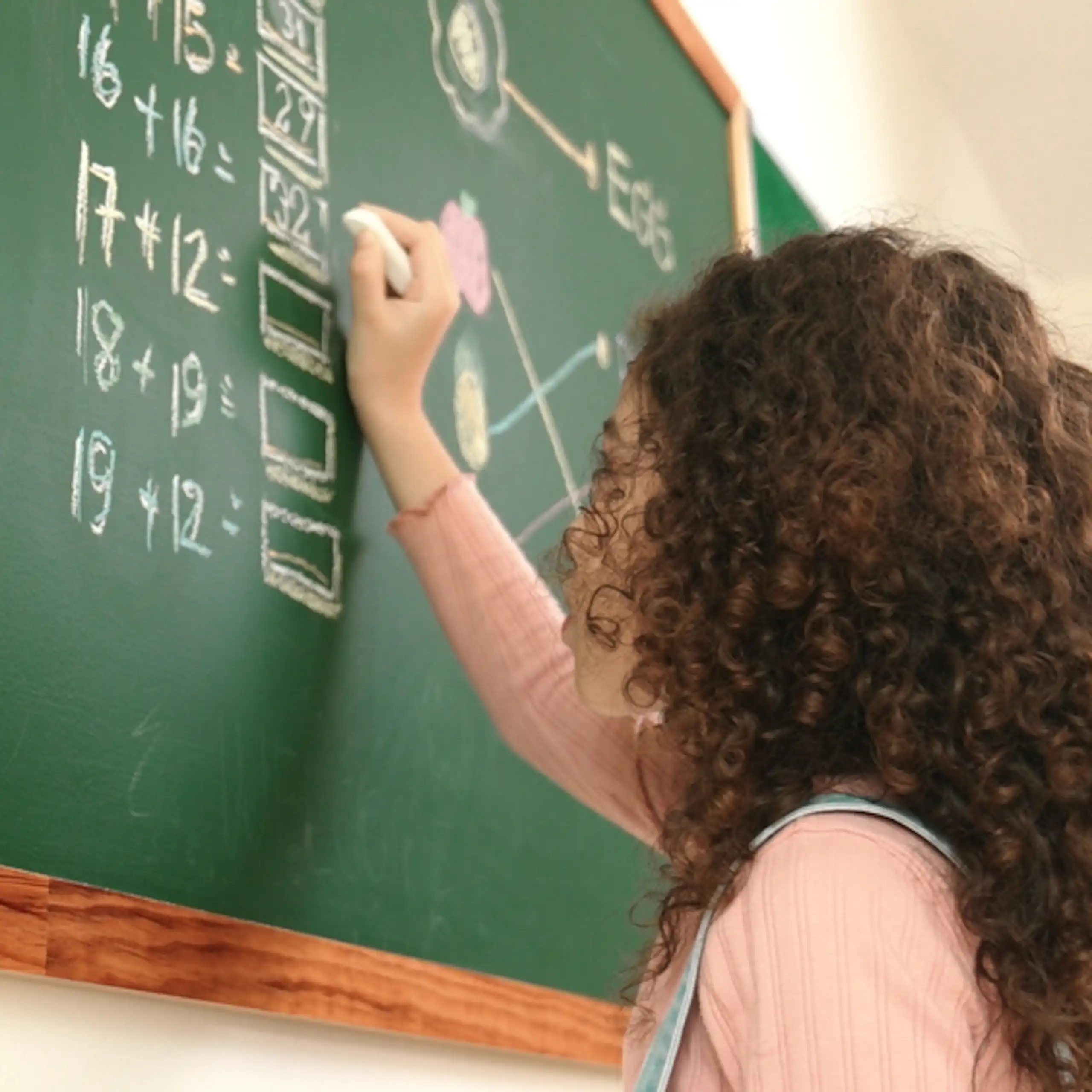 Une élève résout des opérations de maths sur un tableau.