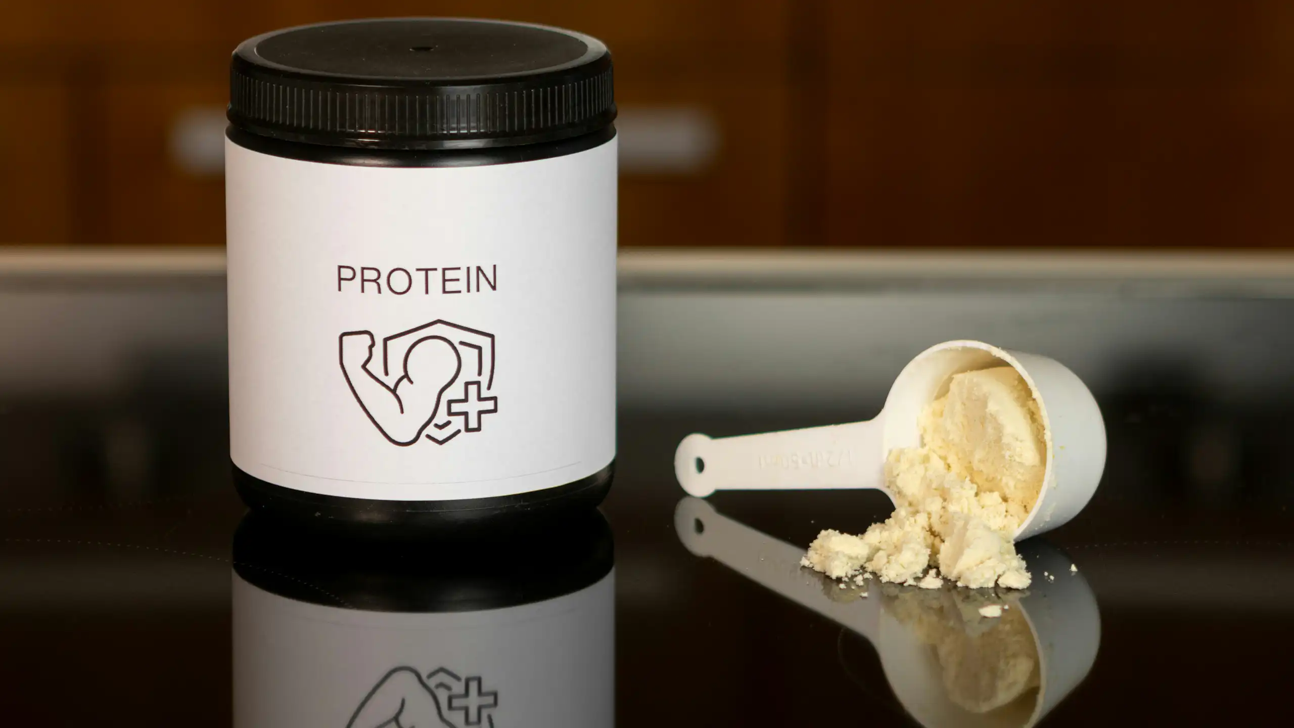 A container of protein powder and a scoop of protein powder