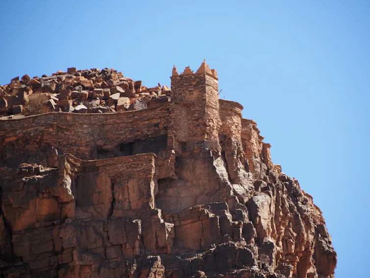La torre de piedra está situada en lo alto de una colina de piedra.