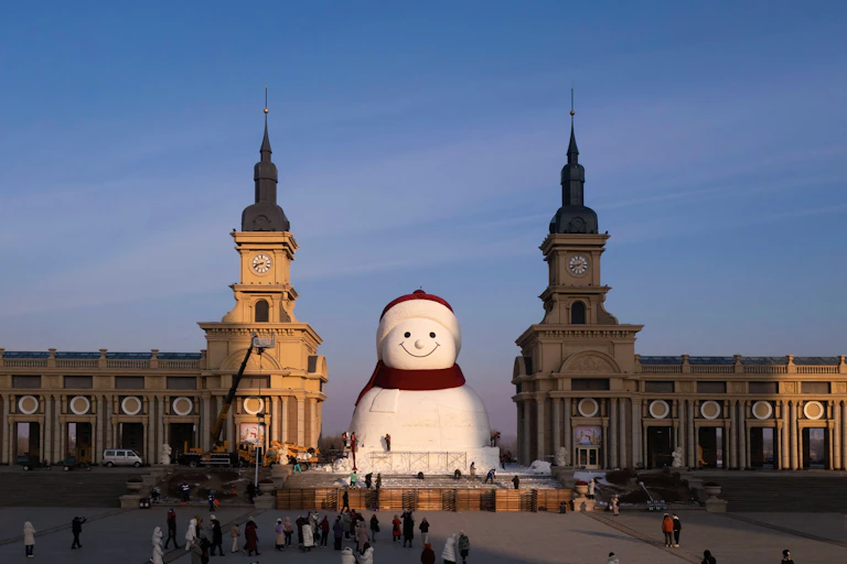 Des ouvriers apportent les dernières finitions à une sculpture géante de bonhomme de neige au parc musical de Qunli, à Harbin, dans la province du Heilongjiang, au nord-est de la Chine, le 15 décembre 2025.