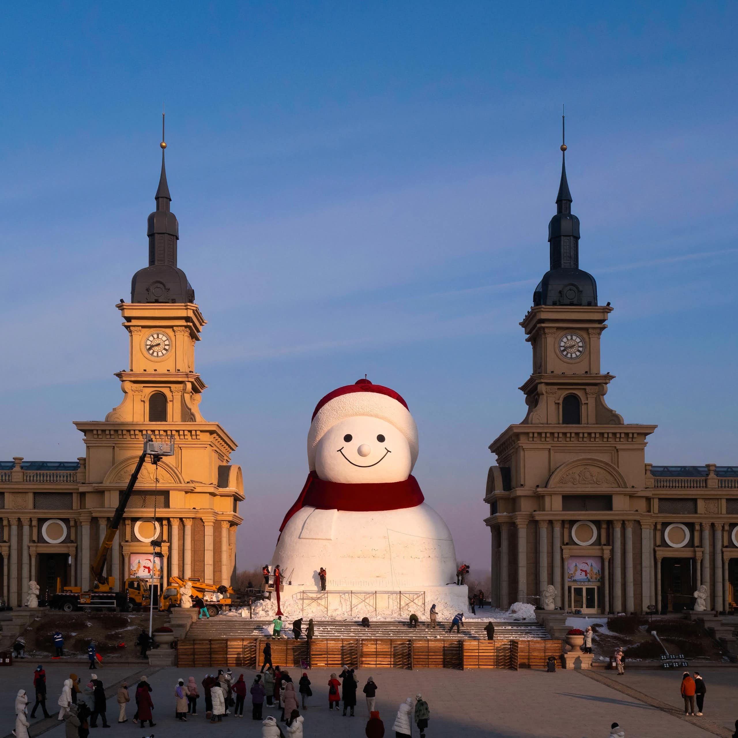 Des ouvriers apportent les dernières finitions à une sculpture géante de bonhomme de neige au parc musical de Qunli, à Harbin, dans la province du Heilongjiang, au nord-est de la Chine, le 15 décembre 2025.