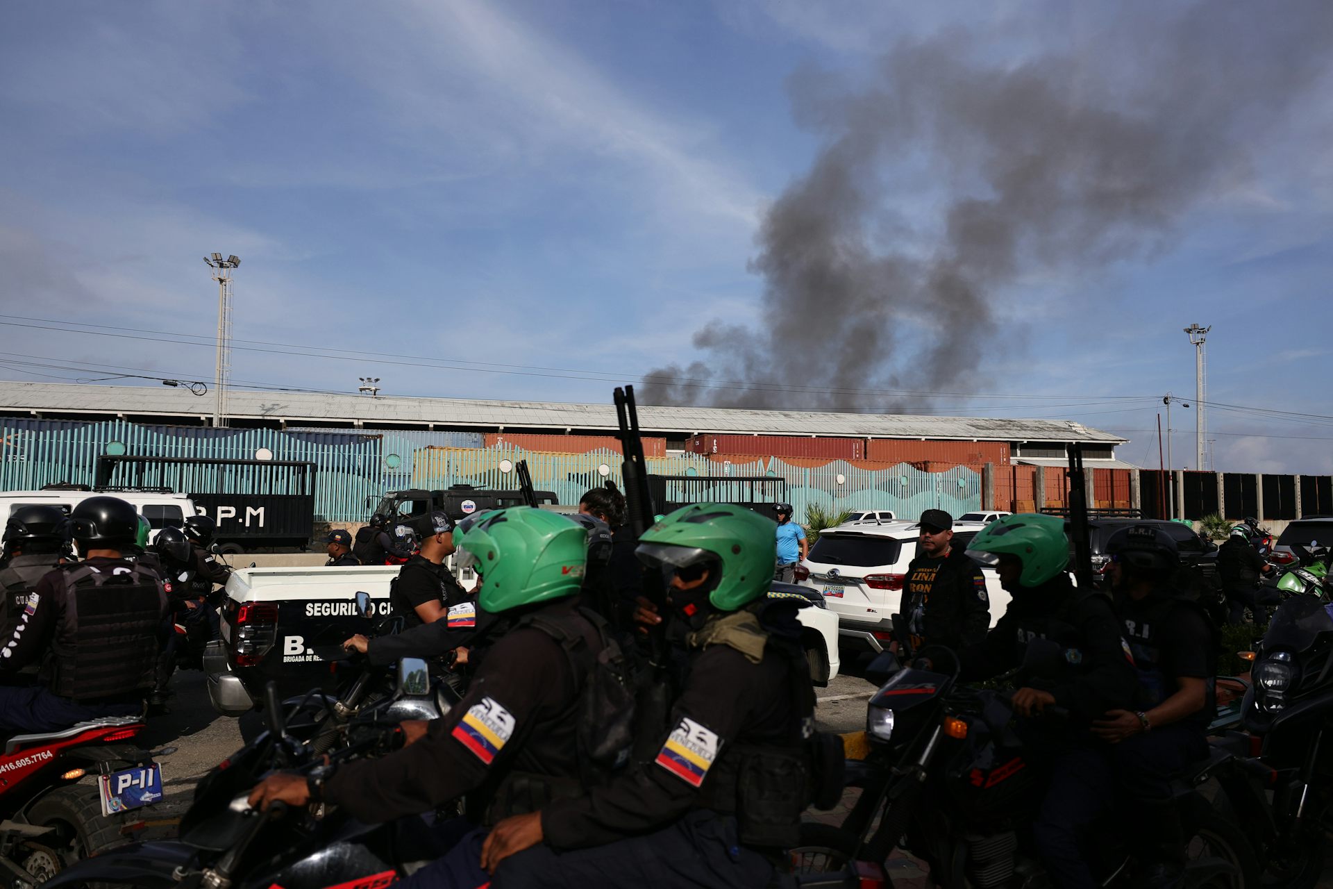 A cloud of black smoke is seen above a building.
