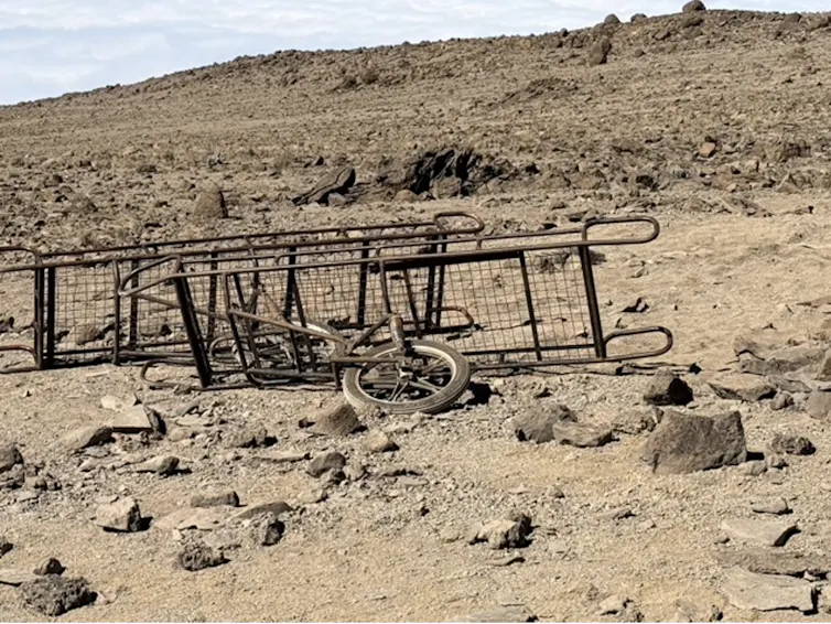 a broken stretcher on wheels on a dusty terrain