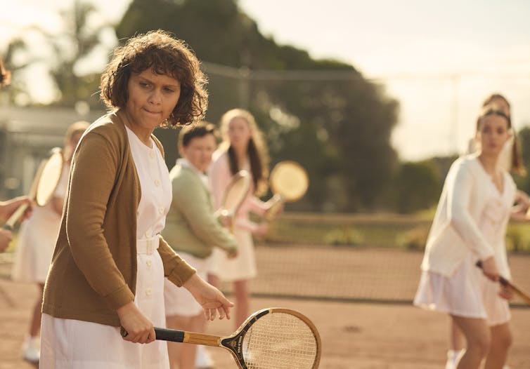 A group of girls on a tennis court.