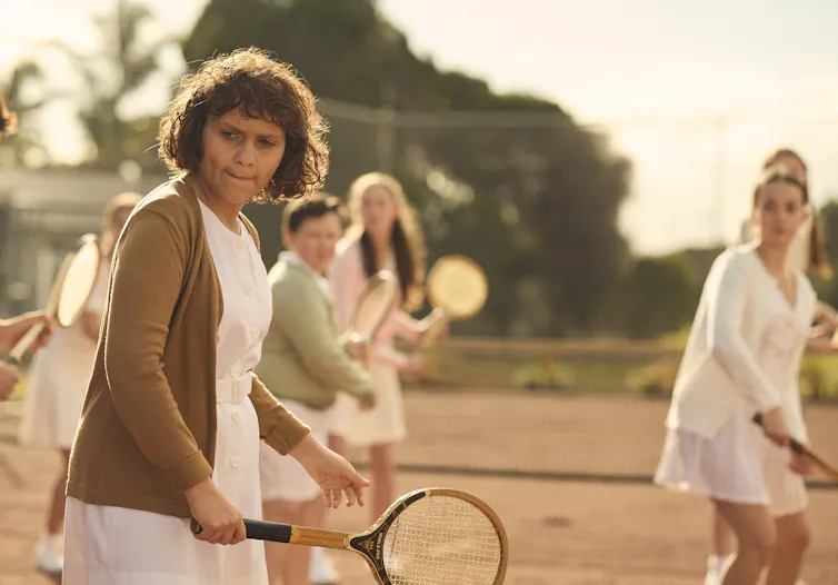 A group of girls on a tennis court.