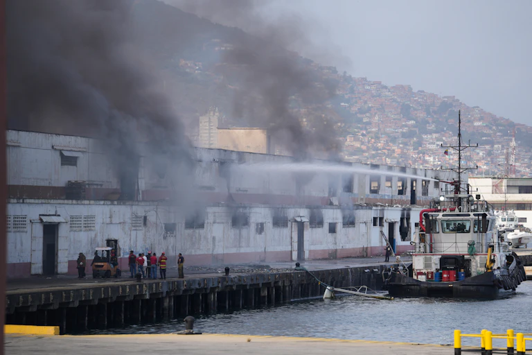 Asap membubung dari dermaga setelah ledakan terdengar di Pelabuhan La Guaira, Venezuela, Sabtu, 3 Januari 2026.