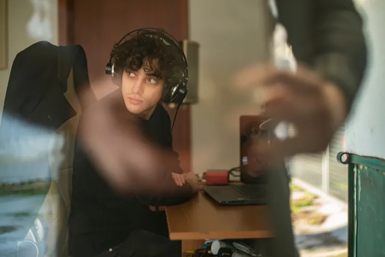 Un étudiant avec un casque qui travaille à son bureau