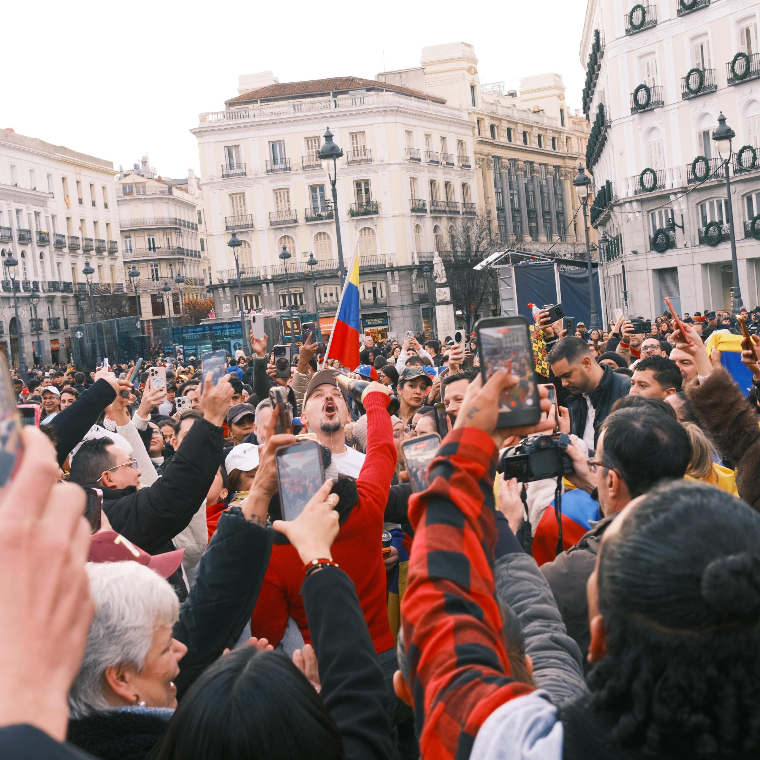 A crowd of Venezuelans celebrate the news of Nicolás Maduro's capture in Puerta del Sol, Madrid.