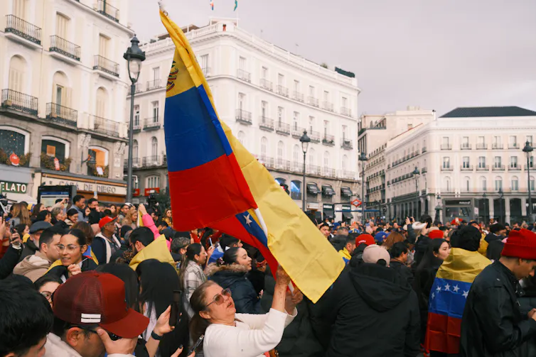 A woman waves the Venezuelan flag during celebrations in Madrid.