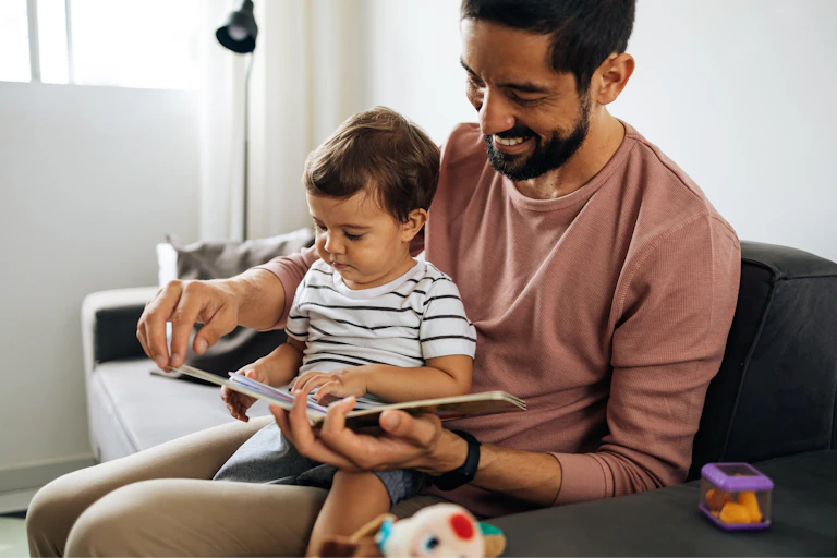 Man and baby looking at book together