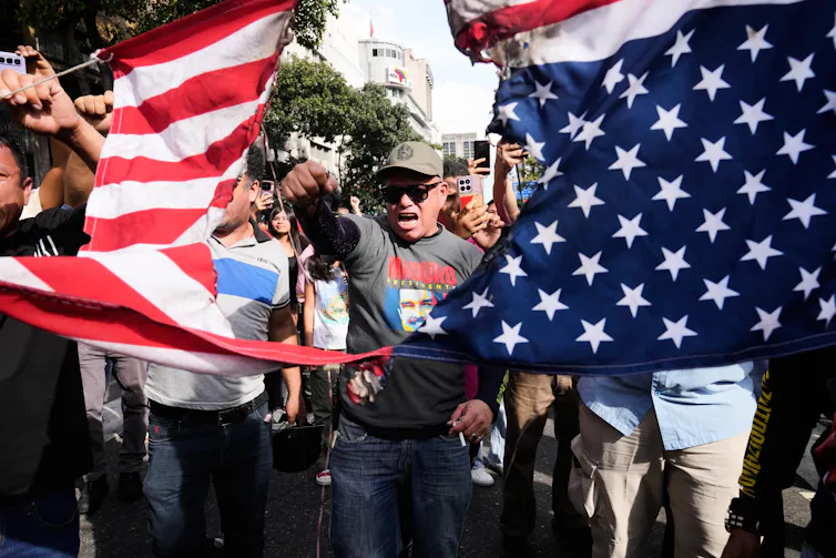 A man rips an American flag in half.