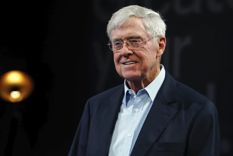 An older white man in glasses and a suit
