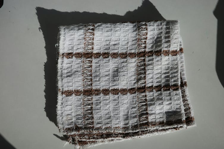 A slightly ratty waffle cloth towel on a counter.
