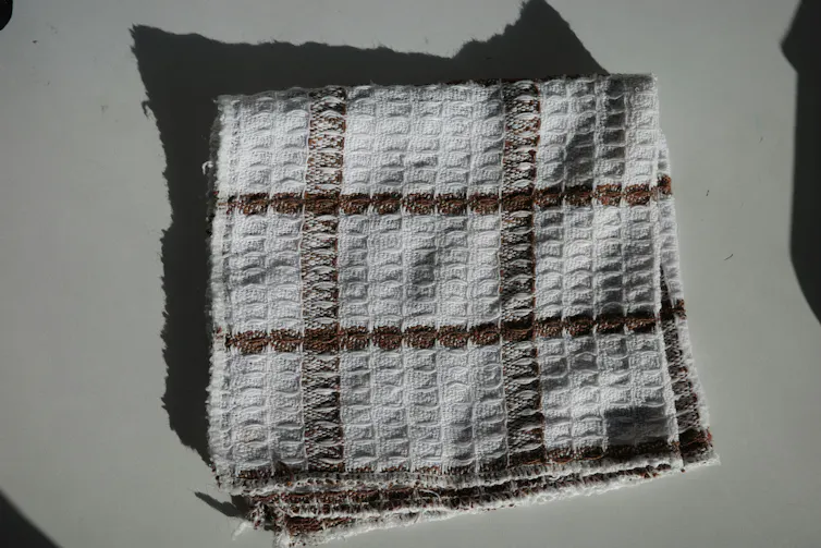 A slightly ratty waffle cloth towel on a counter.